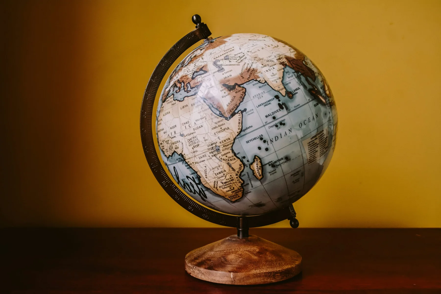 Brass globe and business materials on a dark executive desk