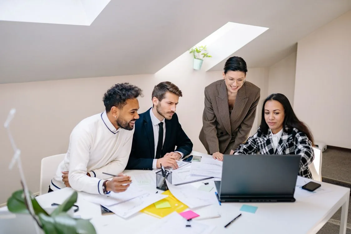 Business professionals collaborating around a laptop
