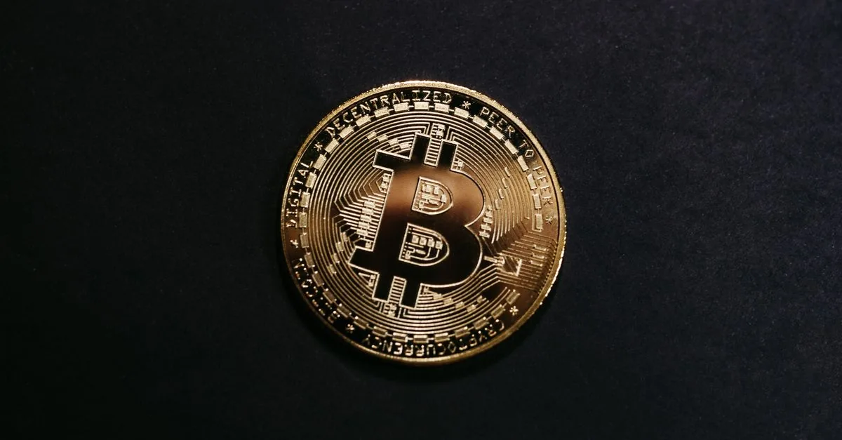 Gold-colored Bitcoin token on a dark, unmarked background